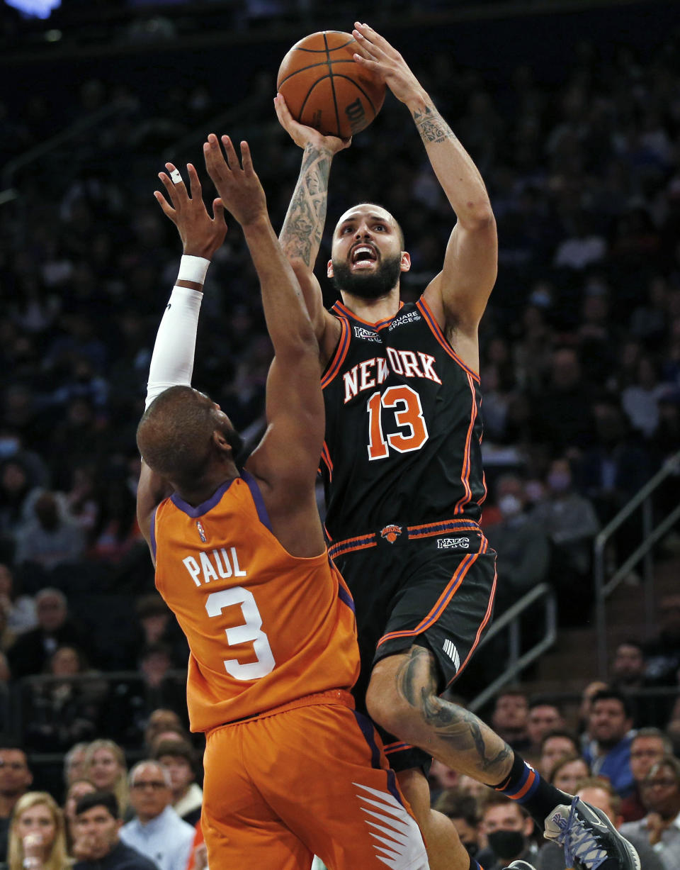 New York Knicks' Evan Fournier (13) shoots over Phoenix Suns' Chris Paul (3) during the first half of an NBA basketball game Friday, Nov. 26, 2021, in New York. AP Photo/John Munson)