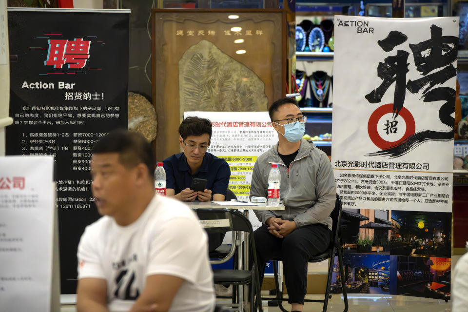 FILE - Recruiters sit at a booth during a job fair held in a shopping center in Beijing, on June 9, 2023. A record of more than one in five young Chinese are out of work, their career ambitions at least temporarily derailed by a depressed job market as the economy struggles to regain momentum after its long bout with COVID-19. (AP Photo/Mark Schiefelbein, File)