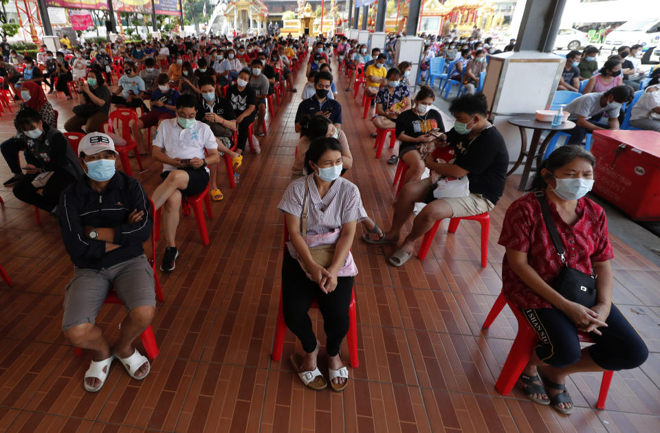 People wait to receive the Sinovac COVID-19 vaccine in Bangkok, Thailand, Monday, April 12, 2021. Thailand's Health Ministry warned Sunday that restrictions may need to be tightened to slow the spread of a fresh coronavirus wave, as the country hit a daily record for new cases. (AP Photo/Sakchai Lalit)