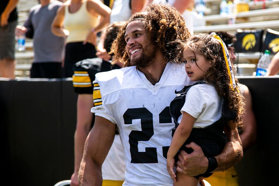 Iowa defensive back Xavior Williams (23) holds his daughter Miley after the Hawkeyes football Kids Day at Kinnick open practice, Saturday, Aug. 14, 2021, at Kinnick Stadium in Iowa City, Iowa.