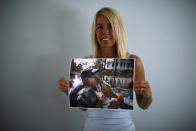 Animal protection volunteer Jane Garrison poses with a picture taken during a pet rescue after Hurricane Katrina in New Orleans, at her house in Palm Springs, California, August 6, 2015. Garrison travelled to New Orleans to assist after the hurricane struck. (REUTERS/Carlos Barria)