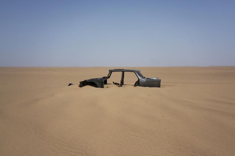 FILE - In this Sunday, June 3, 2018 file photo the frame of an abandoned Peugeot 404 rests in Niger's Tenere desert region of the south central Sahara. Once a well-worn roadway for overlander tourists, the highway‚Äôs 4,500 kilometers (2,800 miles) are a favored path for migrants heading north in hopes of a better life _ and more recently thousands who are being expelled south from Algeria. (AP Photo/Jerome Delay, File)