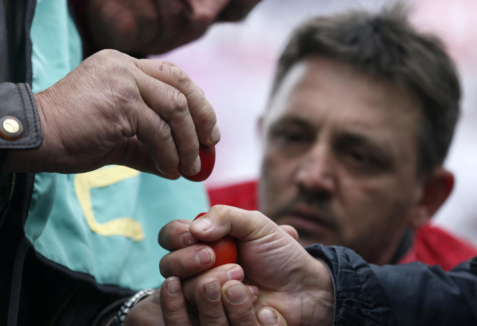 People break decorated Easter eggs as a part of the tradition of celebrating Easter in the village of Mokrin, 120 kilometers (75 miles) north of Belgrade, Serbia, Sunday, April 20, 2014. The egg cracking contest, is an ancient folk tradition that takes place in this northern Serbian village. Two people bang dyed hard-boiled eggs together. The egg that cracks first is the loser; the other goes on to knock again. (AP Photo/Darko Vojinovic)