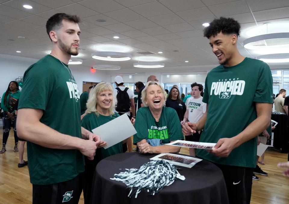 Stetson's Aubin Gateretse (right) and Josh Smith sign autographs for fans during the Hatters' NCAA Tournament selection show watch party, Sunday, March 17, 2024.