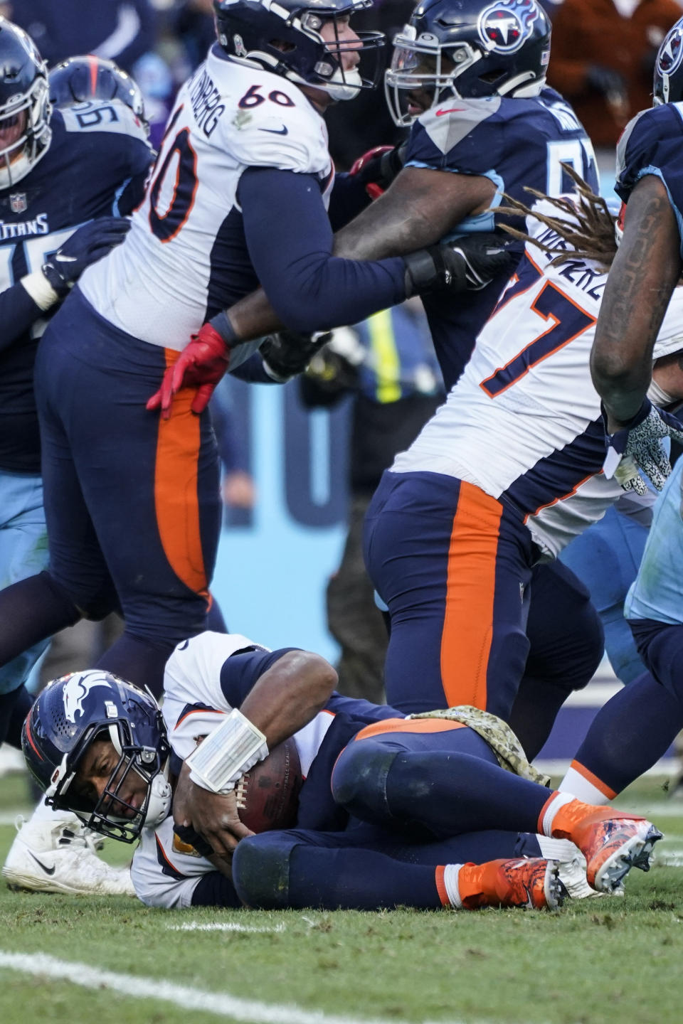 Denver Broncos quarterback Russell Wilson (3) recovers the ball after a bad snap against the Tennessee Titans during the second half of an NFL football game, Sunday, Nov. 13, 2022, in Nashville, Tenn. (AP Photo/Mark Humphrey)
