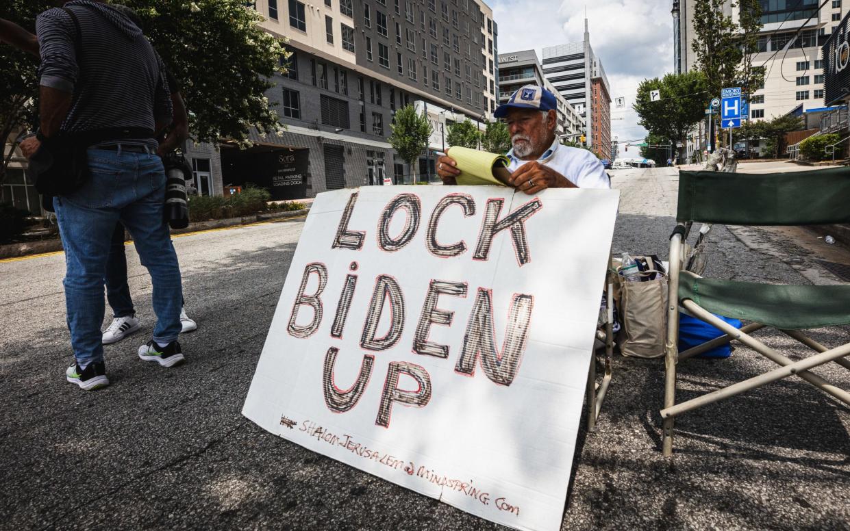 A Trump supporter holds a 'Lock Biden Up' sign ahead of tonight's debate