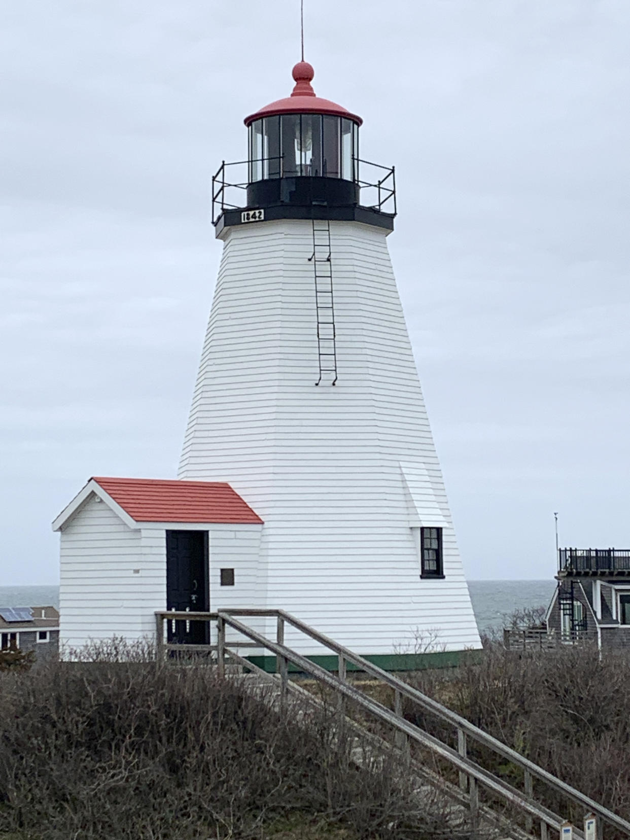 Plymouth Light Station, with an octagonal wooden structure dates to 1842, stands near Cape Cod Bay and Plymouth Bay, April 5, 2023, in Plymouth, Mass. The federal government's annual effort to give away or sell lighthouses that are no longer needed for navigation purposes includes 10 lighthouses this year. (Paul Hughes/General Services Administration via AP)
