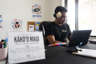 Community care navigator lead Dustin Kaleiopu, right, works at a fire relief and aid services center run by the Council for Native Hawaiian Advancement, Monday, July 8, 2024, in Kahului, Hawaii. The center operates as a relief aid hub for those affected by the 2023 wildfires. (AP Photo/Lindsey Wasson)