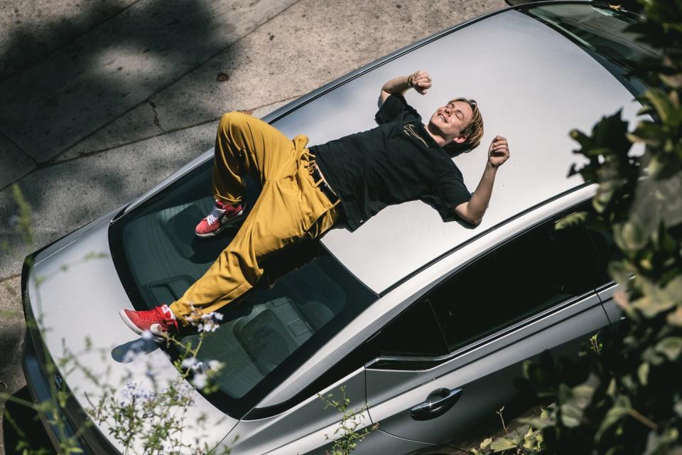 a man lying on top of a car