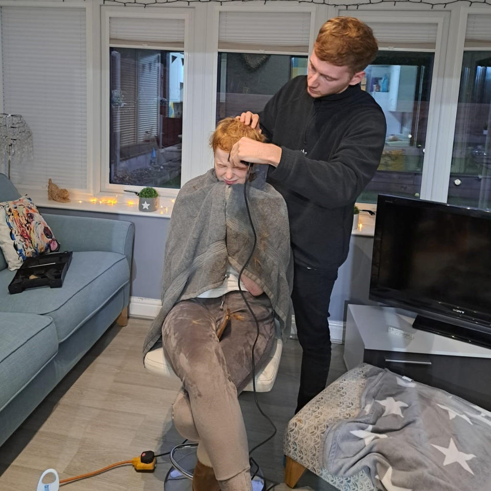 Emily Land having her hair shaved off by her boyfriend Ryan Hammill. (SWNS)