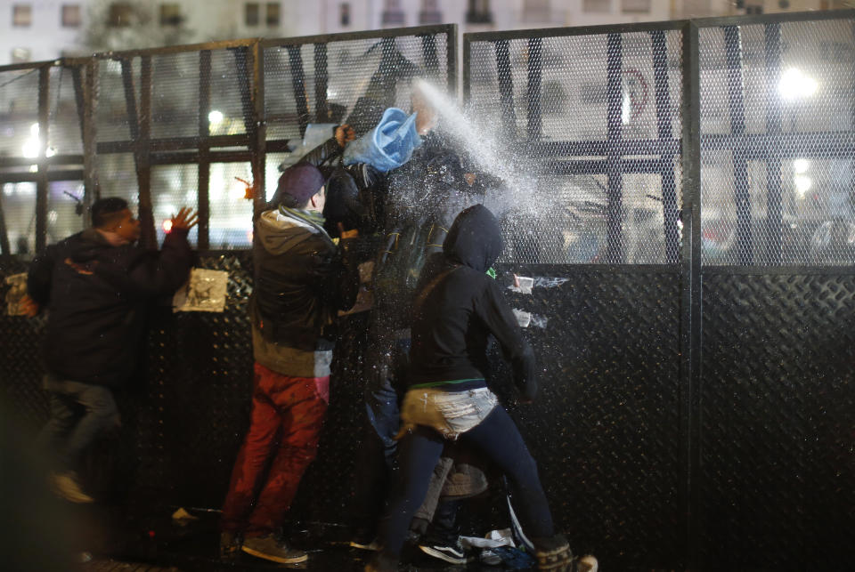 <p>Pro-choice activists confront security forces spraying water from the other side of a mobile barrier wall set up outside Congress, after lawmakers voted against a bill that would have legalized elective abortion in the first 14 weeks of pregnancy, in Buenos Aires, Argentina, early Thursday, Aug. 9, 2018. (Photo: Natacha Pisarenko/AP) </p>