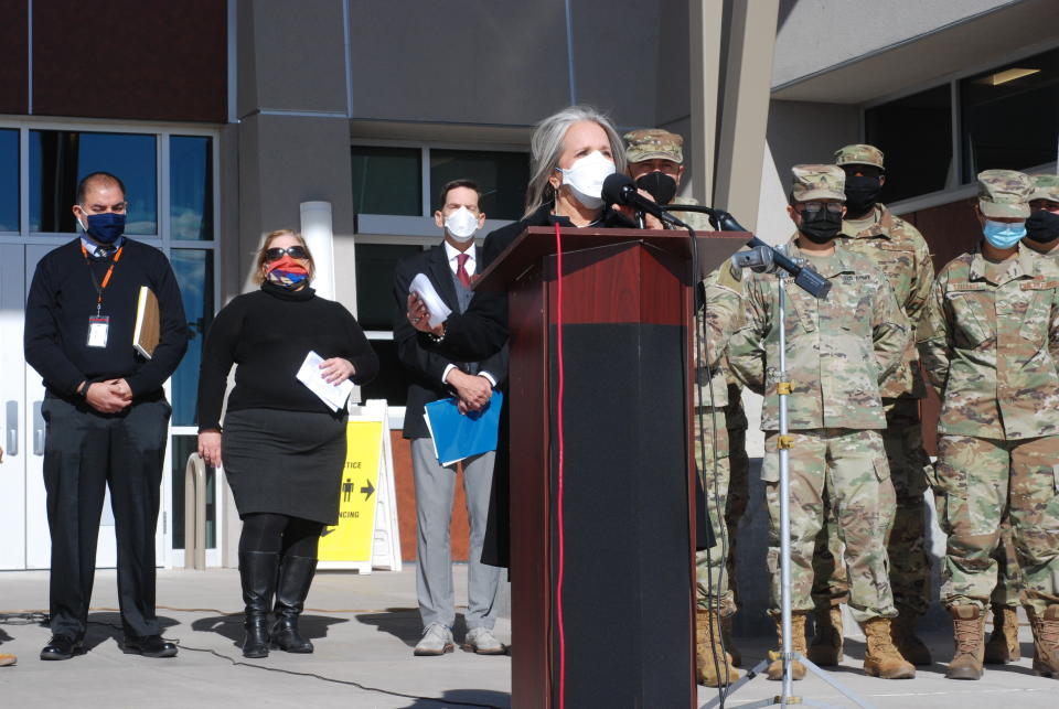 New Mexico Gov. Michelle Lujan Grisham, center, announced efforts to temporarily employ National Guard troops and state bureaucrats as substitute teachers and preschool caregivers, during a news conference at Sante Fe High School in Santa Fe, N.M., on Tuesday, Jan. 19, 2022. New Mexico is is struggling to keep classrooms open amid surging COVID-19 infections. (AP Photo/Morgan Lee)