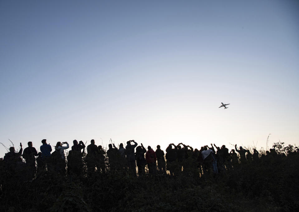Hundreds of people watch and photograph the Airbus of the French airline Air France taking off from Tegel (TXL) airport in Berlin, Germany, Sunday, Nov. 8, 2020. Tegel Airport closes with the departure of the last scheduled flight number AF 1235 to Paris. (Paul Zinken/dpa via AP)