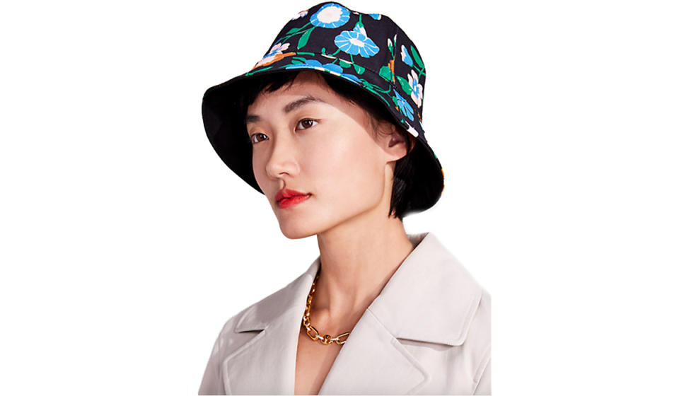 Asian woman wearing a bucket hat with patterned side out.