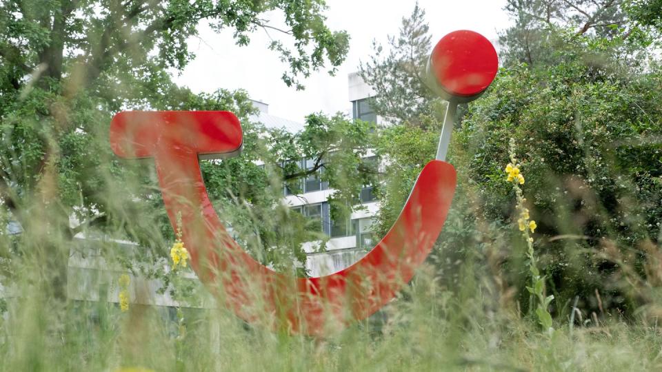 Das Tui-Logo hinter hohem Gras vor der Firmenzentrale in Hannover.