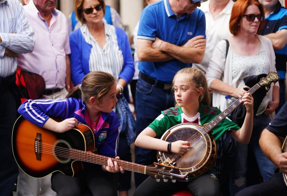 Musicians and sisters Anna Dunleavy (left) and Aoife Dunleavy join a trad session outside Fraynes Bakery on the streets of Mullingar as the Fleadh Cheoil began (Brian Lawless/PA) (PA Wire)