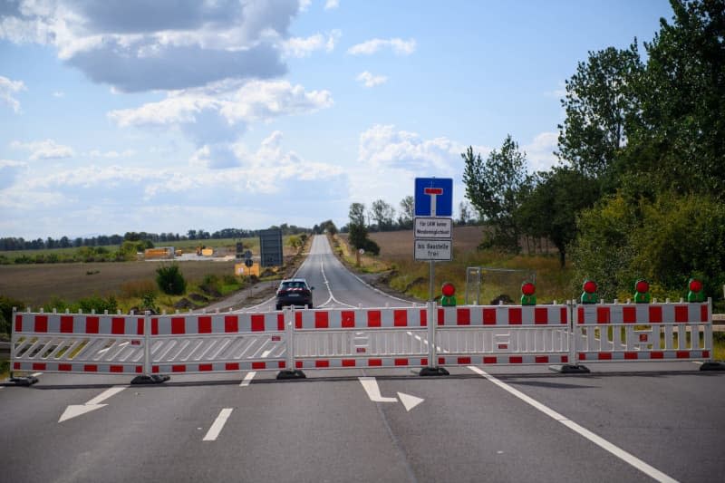 A construction site vehicle drives across a closed road to an access road to the construction site of the Intel chip factory on the "Eulenberg". The chip company Intel is putting the construction of a factory in Magdeburg on hold. The project will probably be delayed by two years, announced company boss Gelsinger. Intel is struggling with losses and has initiated a cost-cutting program. Klaus-Dietmar Gabbert/dpa