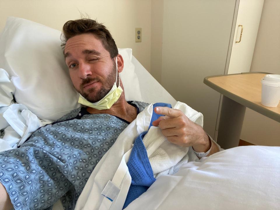 Jeremy Smith grimaces from a hospital bed in Georgia before a procedure to examine brain swelling caused by his long COVID.