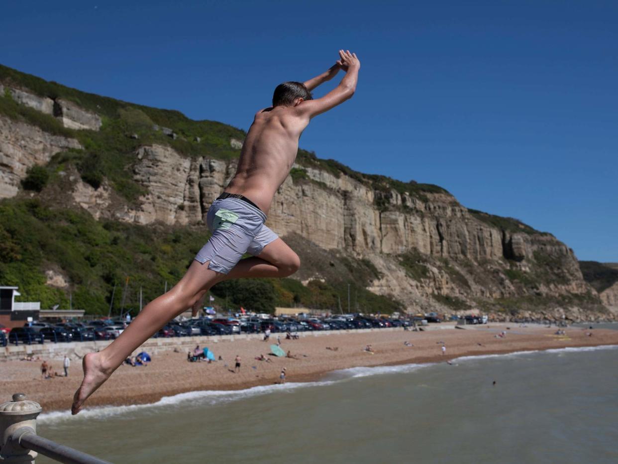 Youngsters jump from a wall into the sea in Hastings: Getty Images