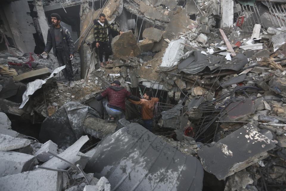 Palestinians look for survivors of the Israeli bombardment of the Gaza Strip in Rafah on Tuesday, Dec. 12, 2023. (AP Photo/Hatem Ali)