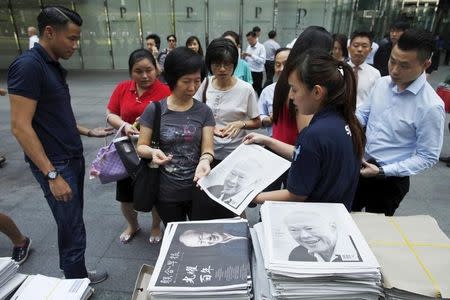 Special editions of newspapers bearing the images of former prime minister Lee Kuan Yew are sold and distributed at the central business district in Singapore March 23, 2015. REUTERS/Edgar Su