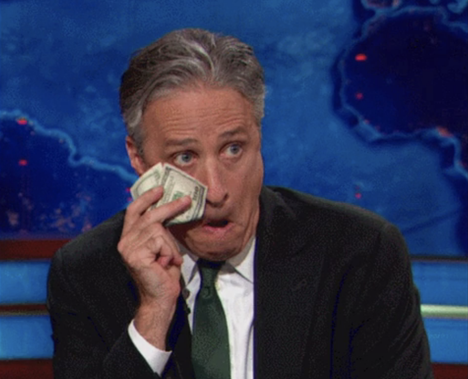 Jon Stewart drying his tears with a 100 dollar bill