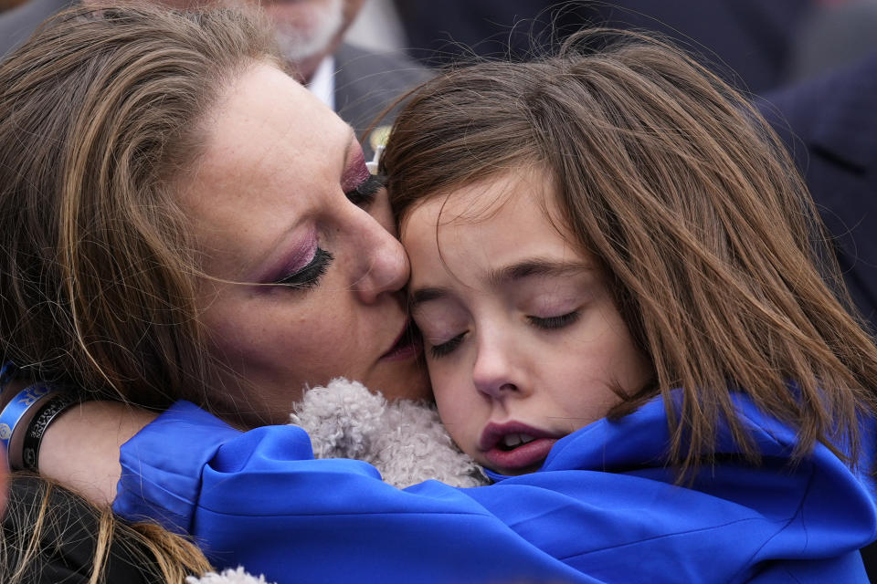 Shannon Terranova, the ex-wife of U.S. Capitol Police officer William "Billy" Evans, embraces her daughter Abigail Evans during a ceremony marking the second year anniversary of the violent insurrection by supporters of then-President Donald Trump, in Washington, Friday, Jan. 6, 2023. William "Billy" Evans was killed in an attack near the Senate side of the Capitol building, where he was manning a barricade in April 2021. (AP Photo/Matt Rourke)