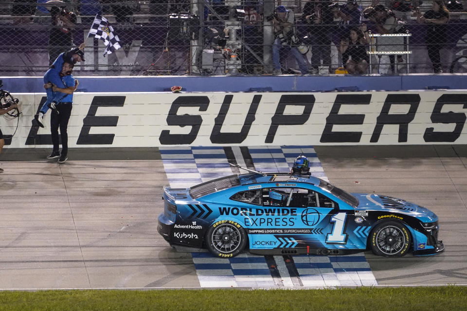 Ross Chastain, holding flag, celebrates after winning a NASCAR Cup Series auto race, late Sunday, June 25, 2023, in Lebanon, Tenn. (AP Photo/George Walker IV)