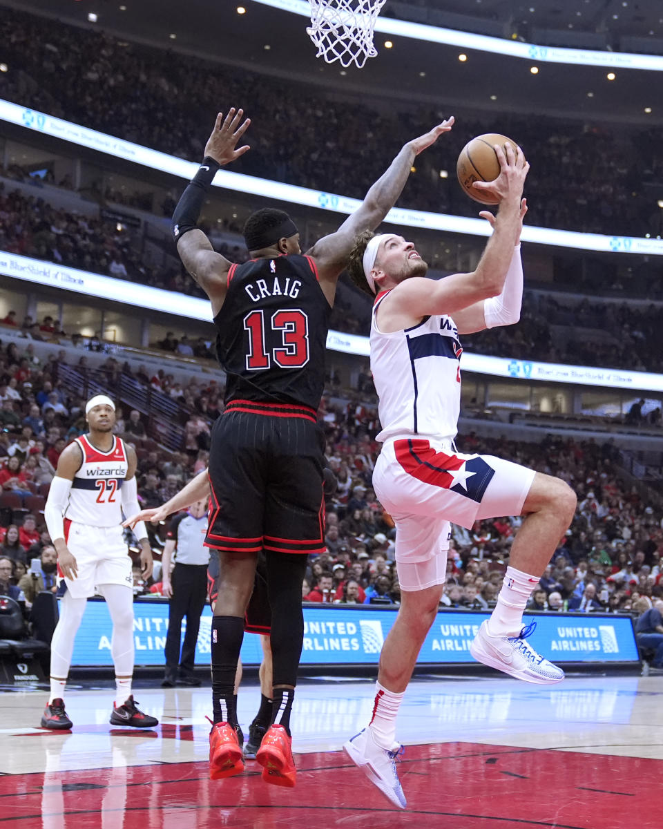 Washington Wizards' Corey Kispert shoots a reverse layup as Chicago Bulls' Torrey Craig defends during the first half of an NBA basketball game Monday, March 25, 2024, in Chicago. (AP Photo/Charles Rex Arbogast)
