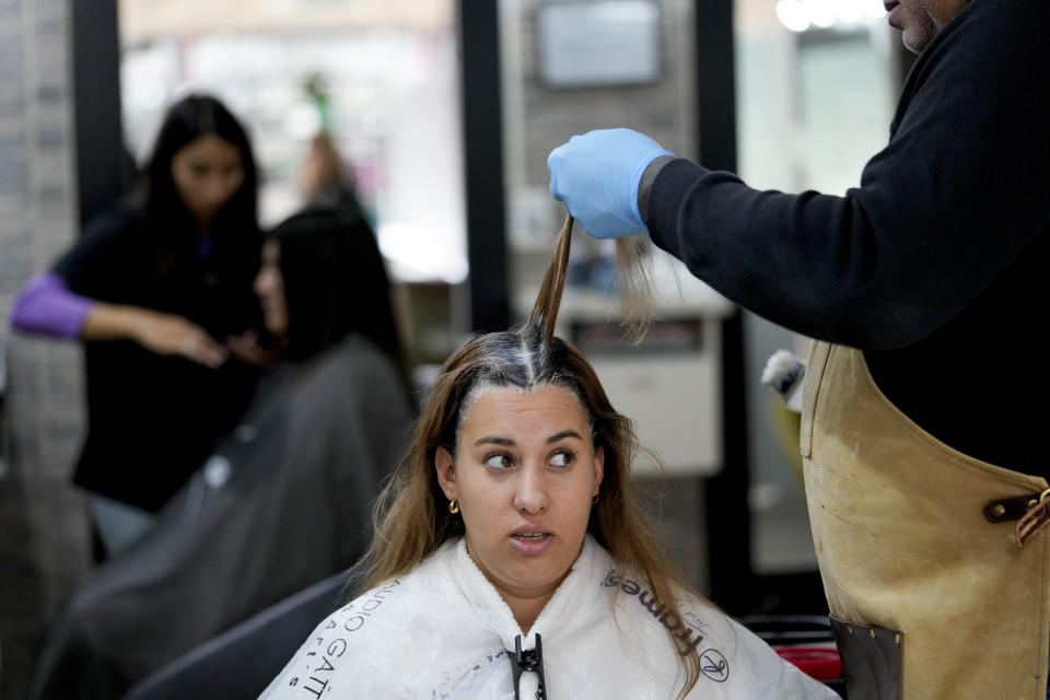 Uruguayan Stella Ferreira gets her hair died at a salon in Gualeguaychu in the Entre Rios province of Argentina, near the Uruguayan border, Friday June 30, 2023. Ferreira, from the Uruguayan town of Fray Bentos, about 45 kilometers (28 miles) away, was on a cross border shopping trip with three friends, snapping up bargains created by different exchange rates as crisis-battered Argentina’s peso has plunged against the U.S. dollar. (AP Photo/Natacha Pisarenko)