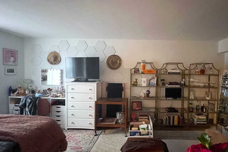 Vanity, dresser, table, and etageres line wall as shelving.