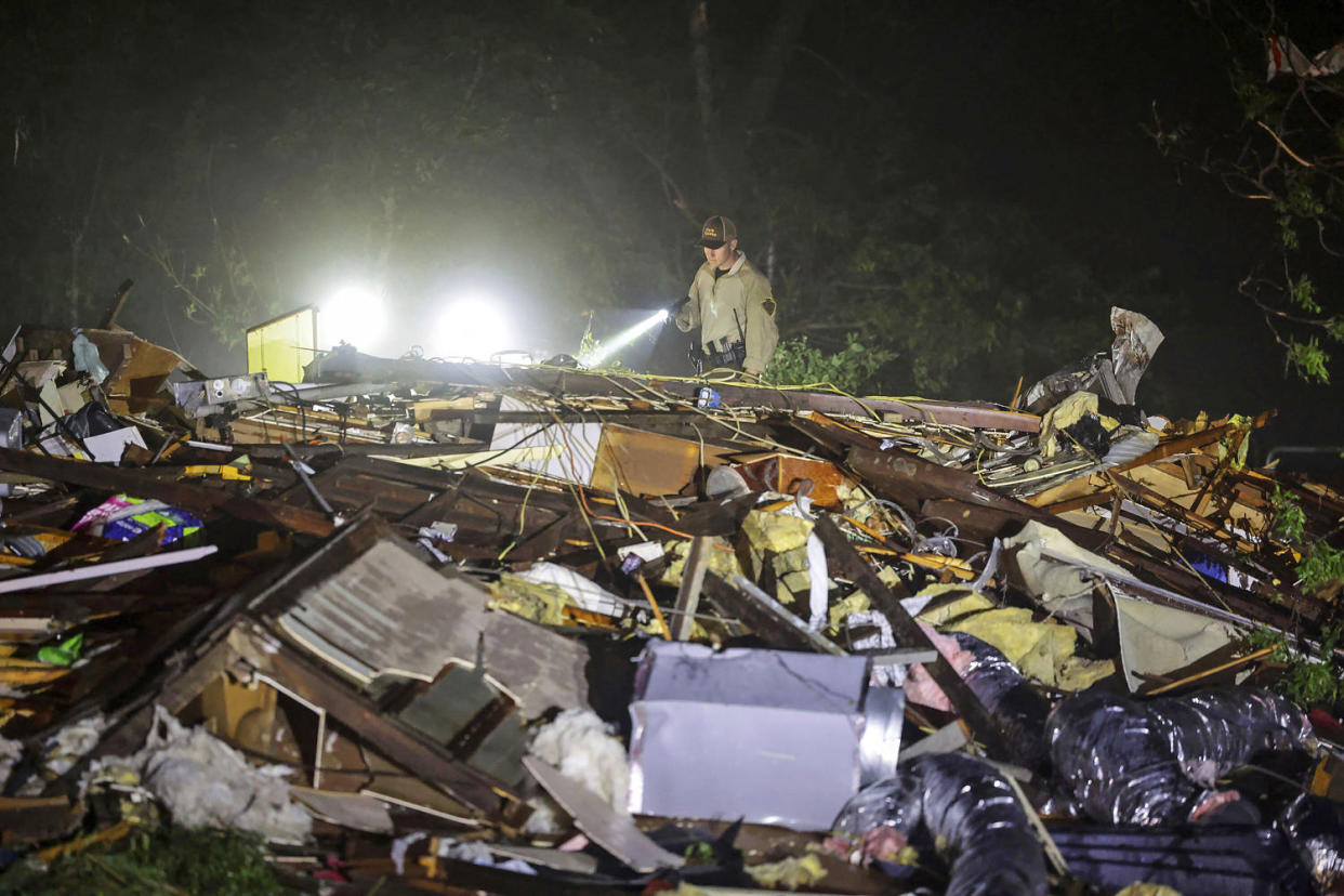 An Oklahoma State Highway Patrol trooper searches through storm damage in Barnsdall, Oklahoma. (Mike Simons / Tulsa World via AP)