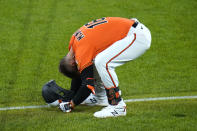 Baltimore Orioles' Trey Mancini smashes his helmet on the grass after grounding out with the bases loaded to end the eighth inning of a baseball game against the Boston Red Sox, Saturday, April 10, 2021, in Baltimore. The Red Sox won 6-4 in ten innings. (AP Photo/Julio Cortez)