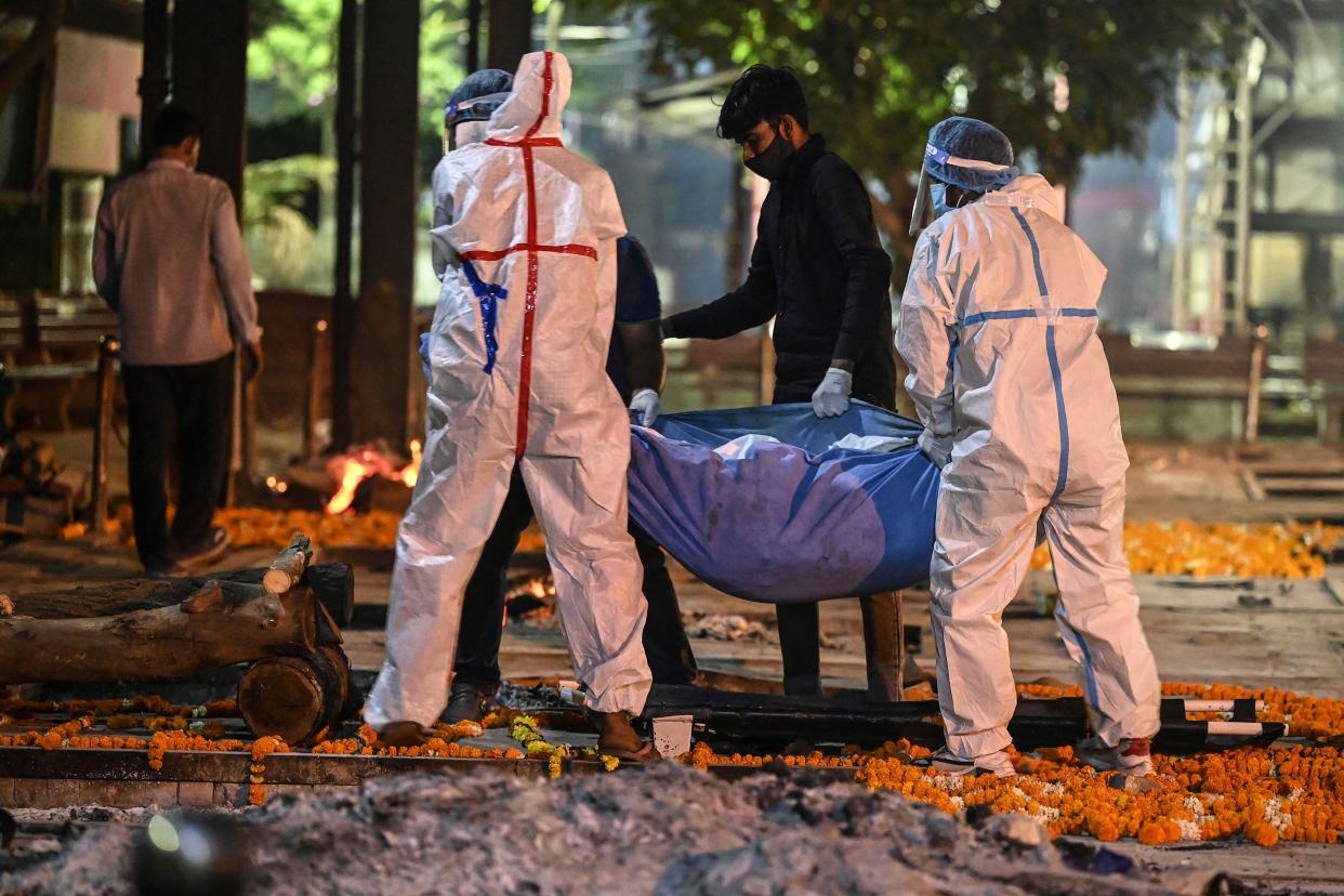 <p>Relatives and family members carry the dead body of a Covid-19 victim for a cremation  in New Delhi</p> (Getty Images)