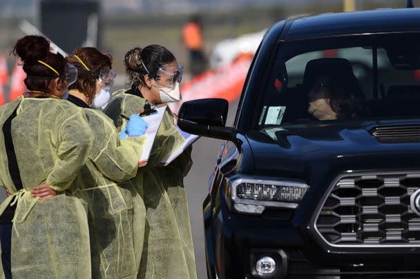 PHOTO: Medical personnel from Riverside (CA) University Health Systems hospitals administer a Coronavirus Test to an individual during drive-through testing in the parking lot of Diamond Stadium, March 22, 2020 in Lake Elsinore, Calif.  (Bob Riha Jr/Getty Images)