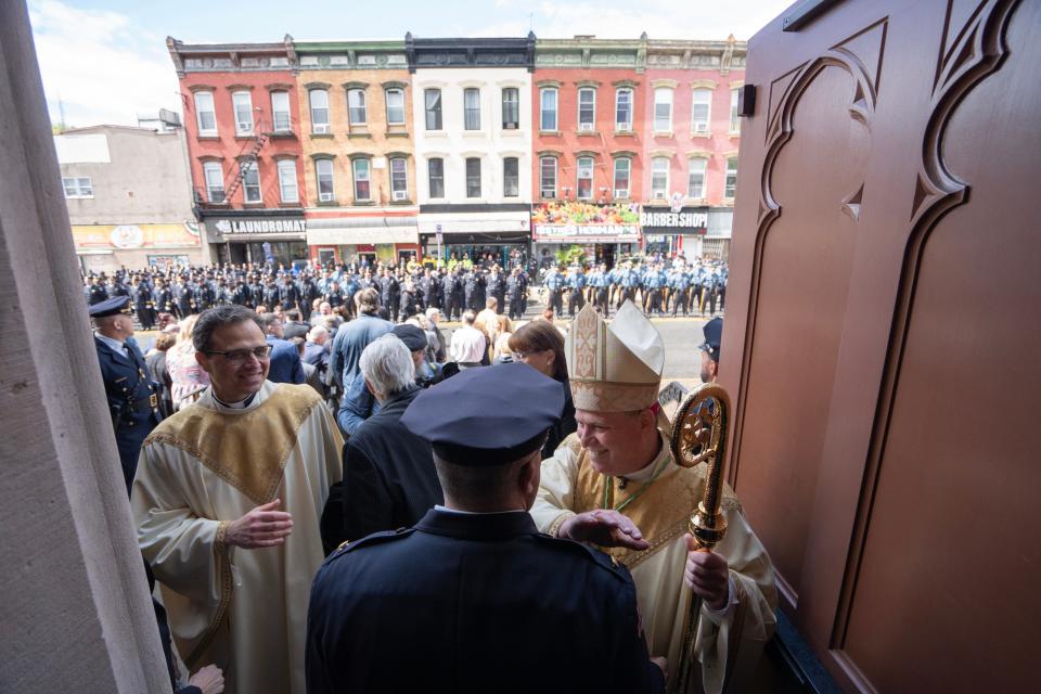 Bishop Kevin J. Sweeney greets police officers as they leave the Cathedral of St. John the Divine after a Blue Mass service on May 2.