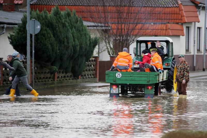 A tractor drives through the flooded village of Windehausen. Stefan Rampfel/dpa