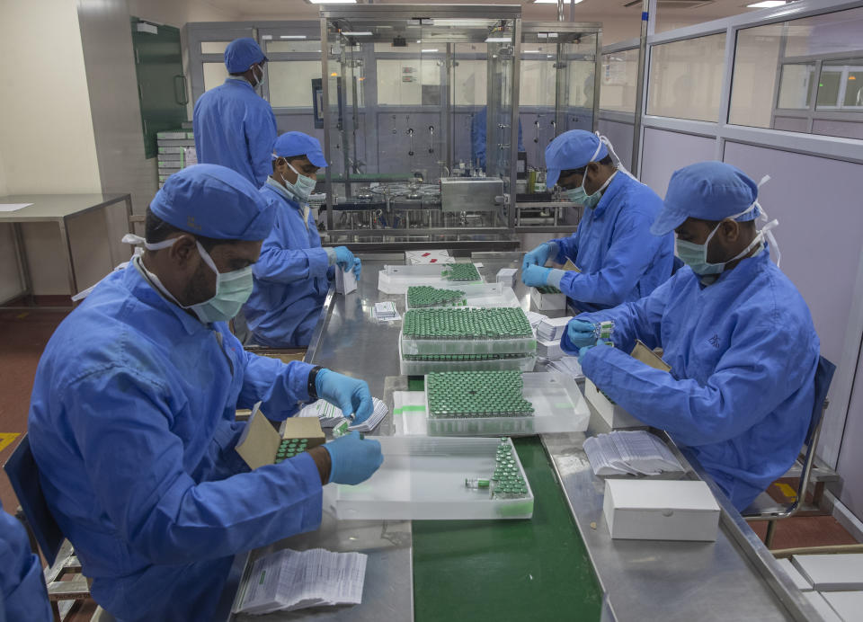 FILE - Employees pack boxes containing vials of Covishield, a version of the AstraZeneca vaccine, at the Serum Institute of India in Pune, Monday, Nov. 22, 2021. COVAX was dealt a blow in March when the Serum Institute of India, which was supposed to be its main supplier, cut off exports to boost domestic vaccine supplies amid a massive surge in coronavirus cases. (AP Photo/Rafiq Maqbool, File)