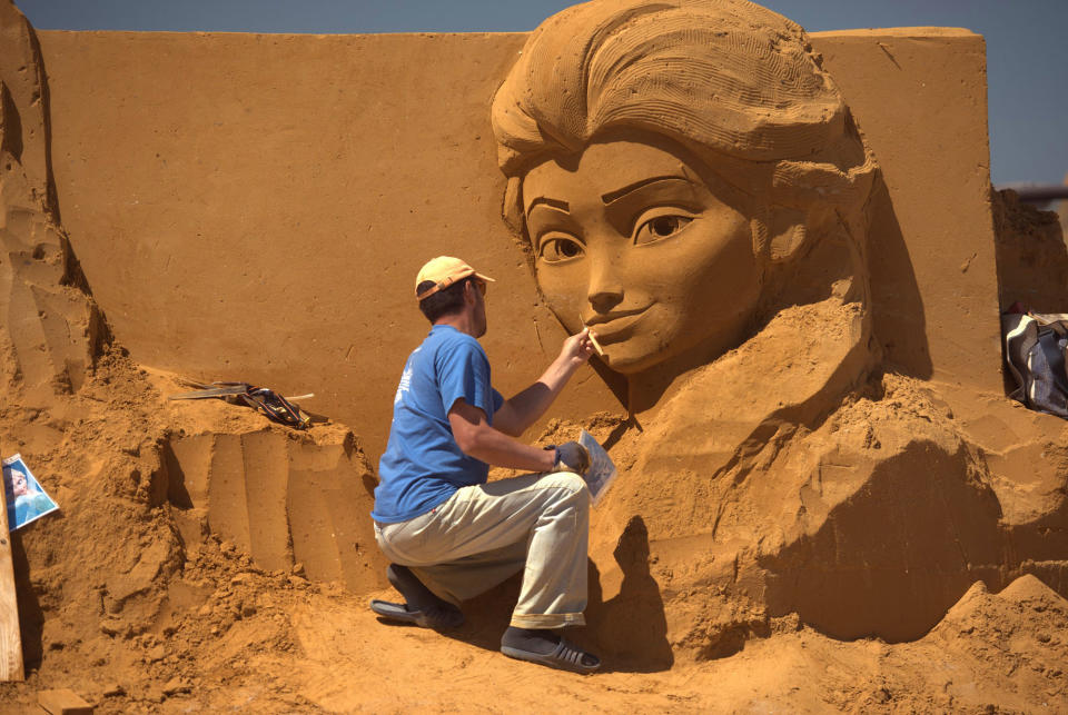 <p>A sand carver works on a sculpture during the Sand Sculpture Festival “Disney Sand Magic” in Ostend, Belgium. (Photo courtesy of Disneyland Paris) </p>