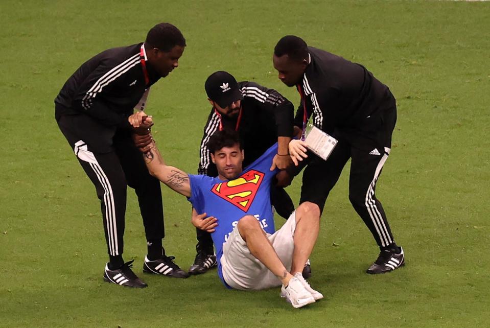 A pitch invader is caught by security during the FIFA World Cup 2022 group H soccer match between Portugal and Uruguay (EPA)