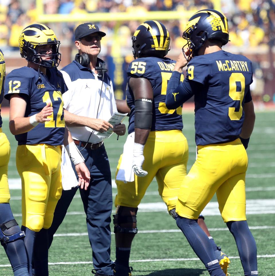 Michigan Wolverines quarterbacks Cade McNamara (12) and J.J. McCarthy (9) and head coach Jim Harbaugh during the 51-7 win against the Colorado State Rams, Saturday, Sept. 3, 2022.