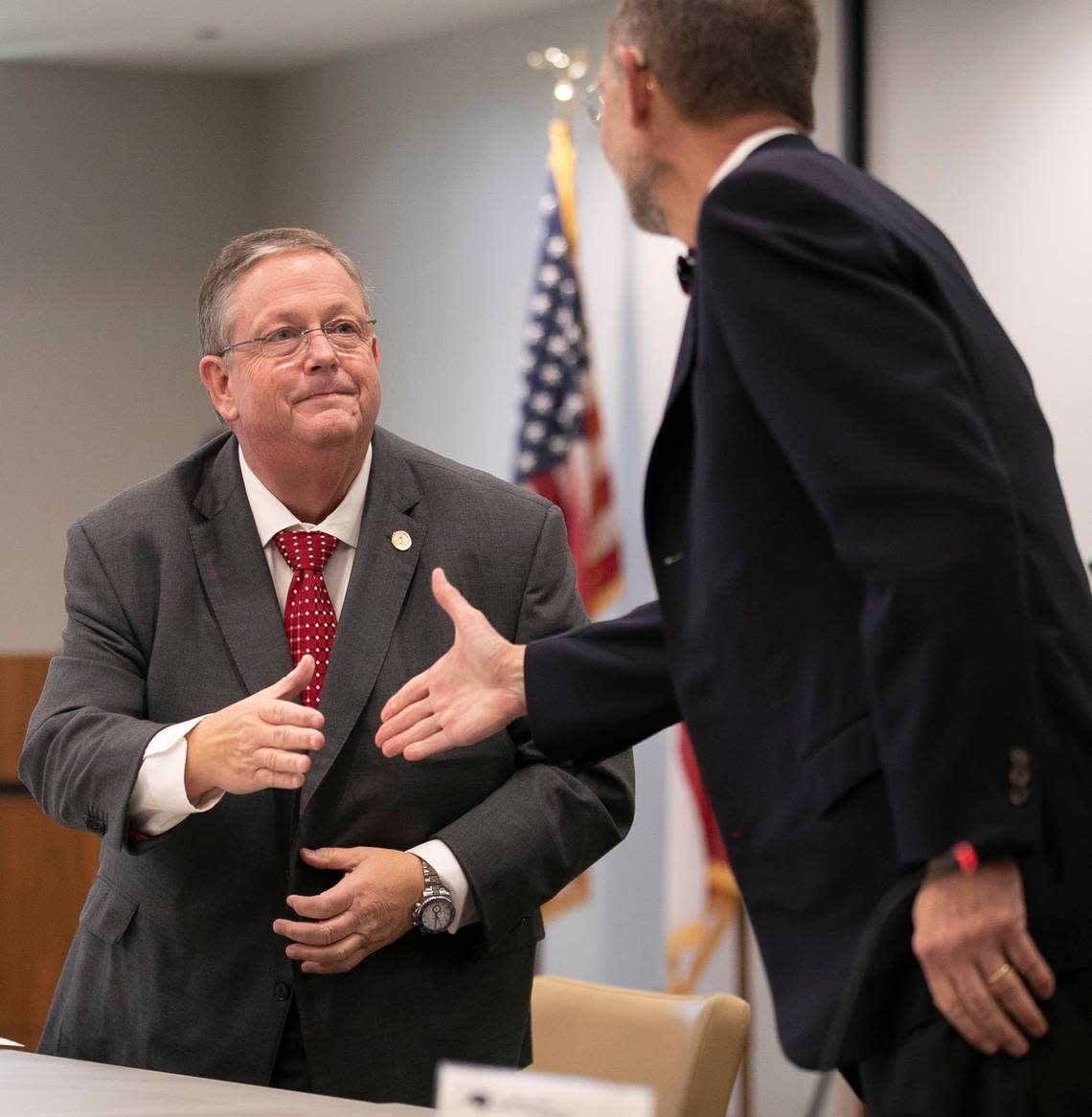 UNC Board of Governors chairman Randall Ramsey, left, shakes hands with Dr. William L. Roper, interim President of the UNC System, as Roper is recognized for his service on Friday, June 19, 2020 in Chapel Hill, N.C.