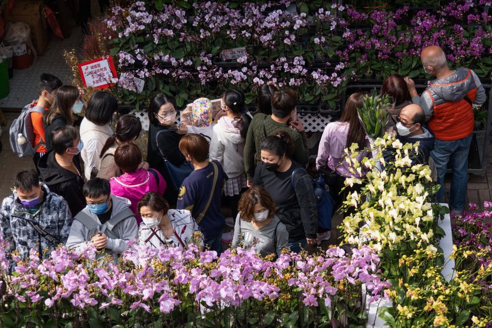 People walk through a flower market in Hong Kongs Prince Edward area on January 16, 2022, ahead of the Chinese Lunar New Year of Tiger. (Photo by Bertha WANG / AFP) (Photo by BERTHA WANG/AFP via Getty Images)