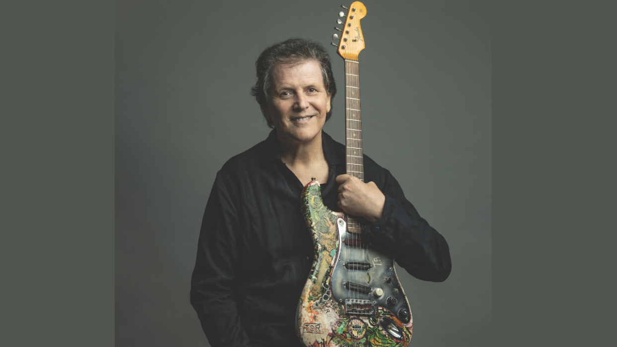  Ex-Yes guitarist Trevor Rabin in a studio-style portrait holding an electric guitar. 
