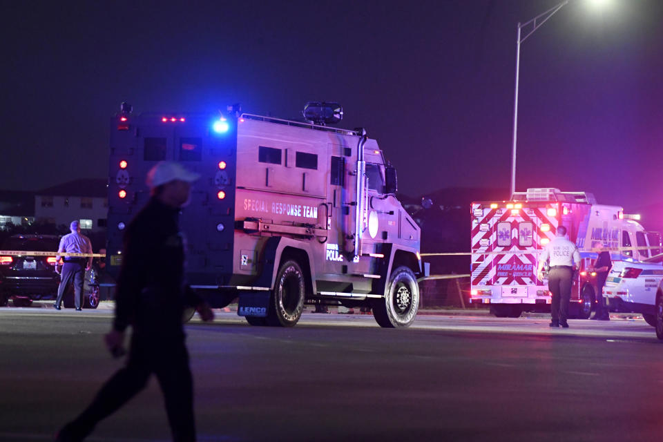 In this Thursday, Dec. 5, 2019, photo authorities investigate the scene of a shooting in Miramar, Fla. The FBI says several people, including a UPS driver, were killed after robbers stole the driver’s truck and led police on a chase that ended in gunfire at a busy South Florida intersection during rush hour. (Taimy Alvarez/South Florida Sun-Sentinel via AP)