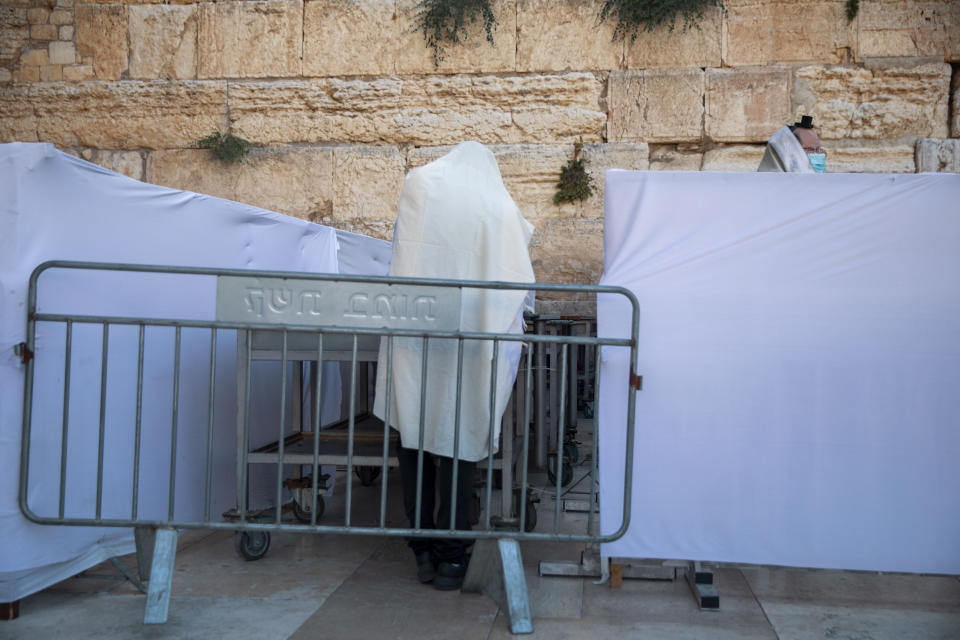 Ultra-Orthodox Jewish men pray in divided sections which allow a maximum of twenty worshipers in line with government measures to help stop the spread of the coronavirus, at the Western Wall, the holiest site where Jews can pray, in Jerusalem's Old City, Thursday, July 16, 2020. (AP Photo/Oded Balilty)