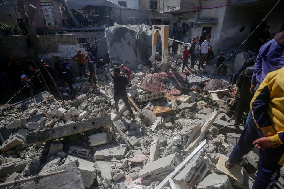 People search for victims in the rubble of the Baraka family home in Deir al-Balah in the central Gaza Strip after it was hit in an Israeli air strike on Sunday, February 18, 2024, amid ongoing battles between Israel and the Palestinian militant group Hamas in the besieged Palestinian territory.