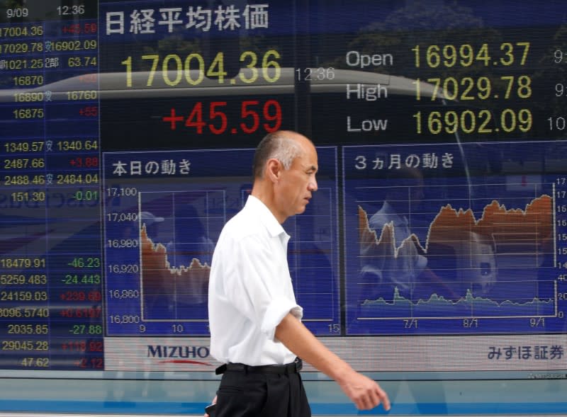 A man walks past a stock quotation board outside a brokerage in Tokyo, Japan, September 9, 2016. REUTERS/Kim Kyung-Hoon