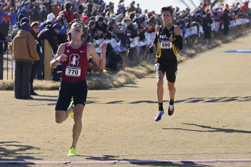 Stanford's Charles Hicks (770) reacts while crossing the finish line ahead of Northern Arizona's Nico Young (699) to win the NCAA men's cross country championship.