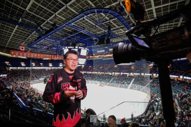 Brian Wong works part-time for the Calgary Flames, producing digital content in a mixture of English and Cantonese. He also talks hockey in Chinese on his popular podcasts. (Submitted by Brian Wong - image credit)